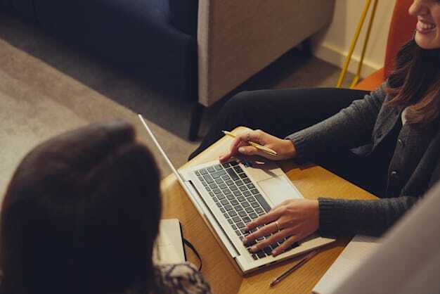 A Woman SmartSearch Employee working on a laptop in AML Meeting